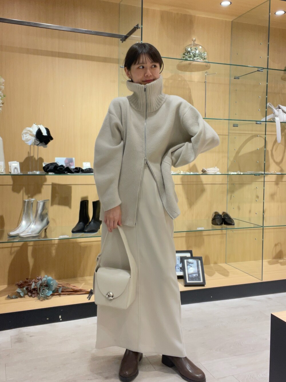 ホワイト系のショルダーバッグ、ホワイト系のその他アウター、ブラウン系のパンプスを着用したレディースの秋コーディネートの3枚目の写真