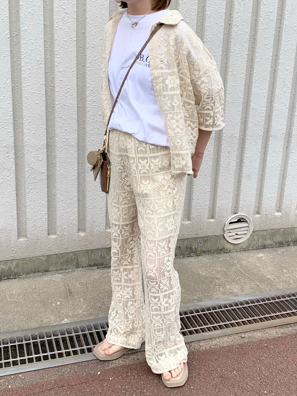 ホワイト系のシャツ/ブラウス、ホワイト系のその他パンツ、ベージュ系のサンダルを着用したレディースの夏コーディネートの2枚目の写真