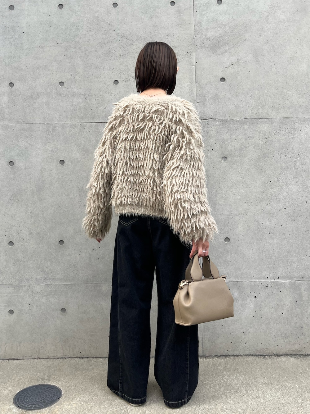 ベージュ系のカーディガン/ボレロ、ベージュ系のショルダーバッグ、ホワイト系のスニーカーを着用したレディースの秋コーディネートの3枚目の写真