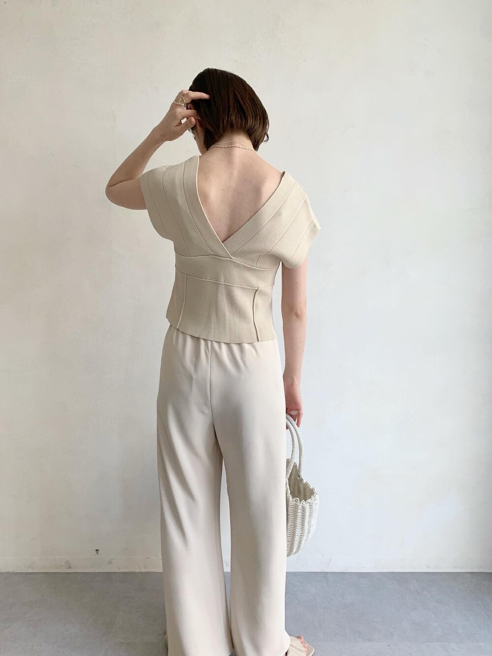 ホワイト系のハンドバッグ、ホワイト系のサンダル、ホワイト系のその他パンツを着用したレディースの夏コーディネートの3枚目の写真