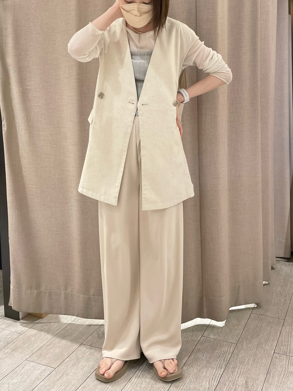 ホワイト系のベスト、ホワイト系のその他パンツ、ベージュ系のサンダルを着用したレディースの春コーディネートの2枚目の写真