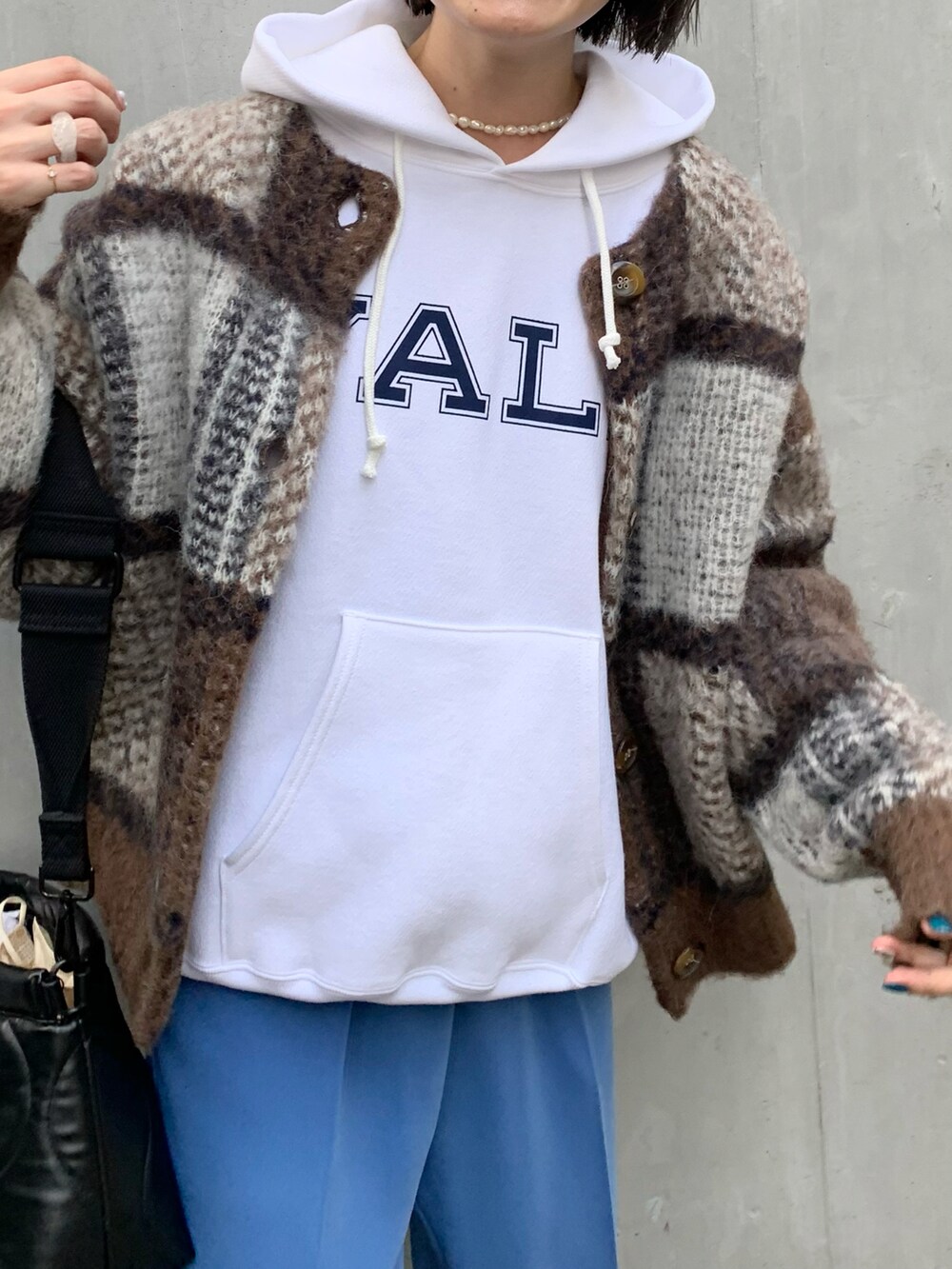 ブルー系のその他パンツ、ブラック系のクラッチバッグ、ブラウン系のカーディガン/ボレロを着用したレディースの冬コーディネートの4枚目の写真