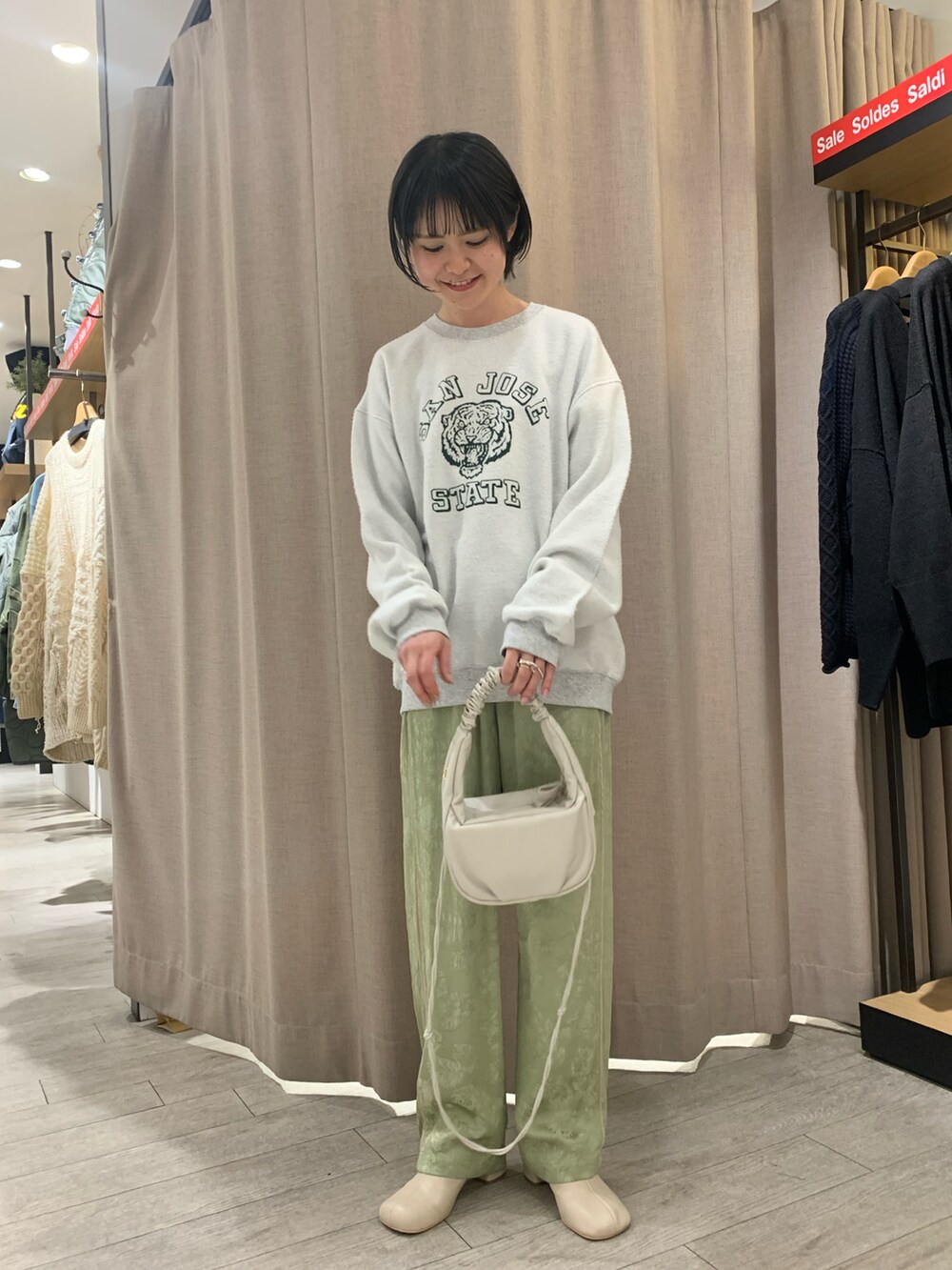 グリーン系のその他パンツ、グレー系のスウェット、ホワイト系のハンドバッグを着用したレディースの冬コーディネートの3枚目の写真