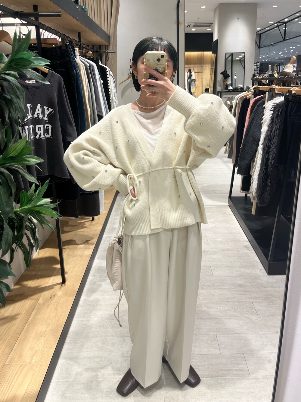 ホワイト系のカーディガン/ボレロ、ホワイト系のバッグ、ブラウン系のブーツを着用したレディースの冬コーディネートの3枚目の写真