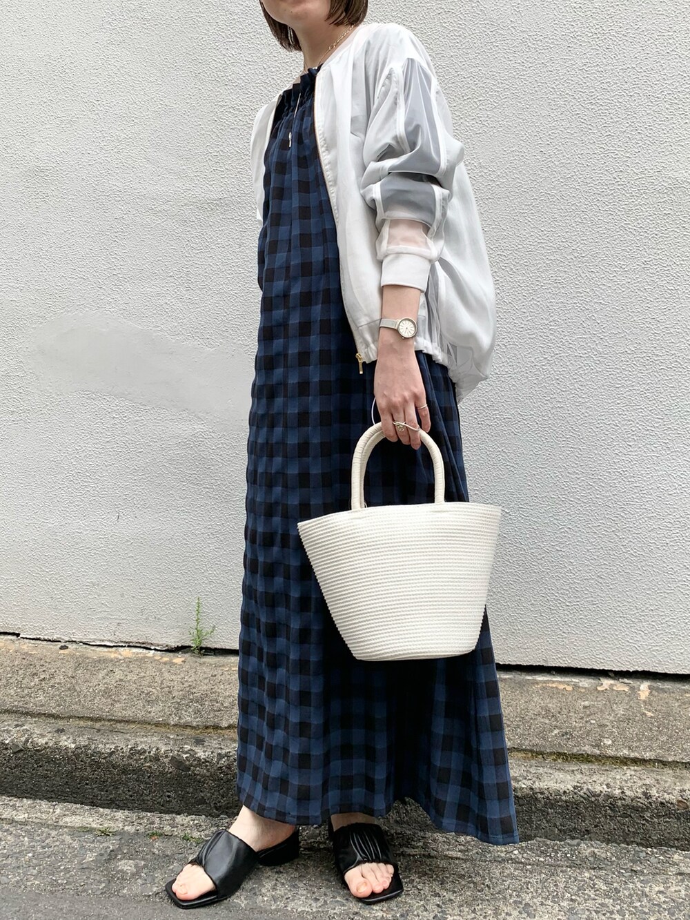 ホワイト系のトートバッグ、ブルー系のワンピース、ホワイト系のブルゾンを着用したレディースの春コーディネートの3枚目の写真