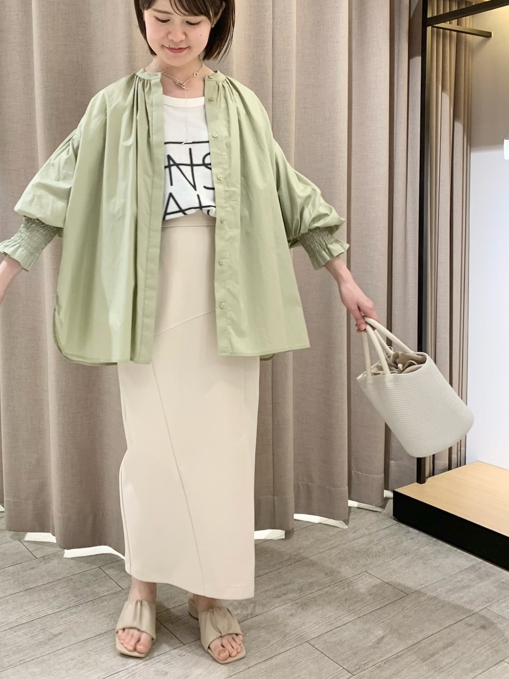 ホワイト系のサンダル、ベージュ系のスカート、ホワイト系のTシャツ/カットソーを着用したレディースの春コーディネートの3枚目の写真