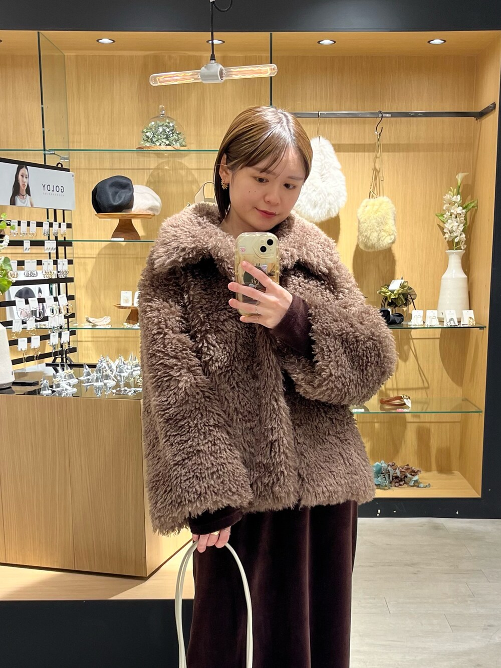 ホワイト系のバッグ、ブラウン系のその他アウター、ブラウン系のブーツを着用したレディースの冬コーディネートの3枚目の写真