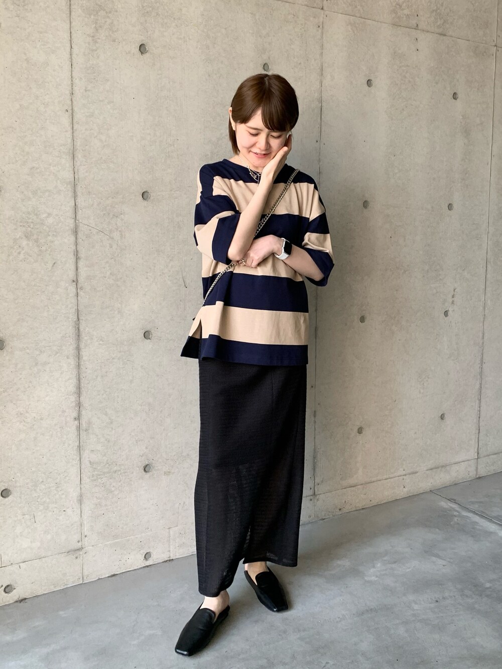 ブラック系のその他シューズ、ブラック系のスカート、ベージュ系のTシャツ/カットソーを着用したレディースの春コーディネートの5枚目の写真