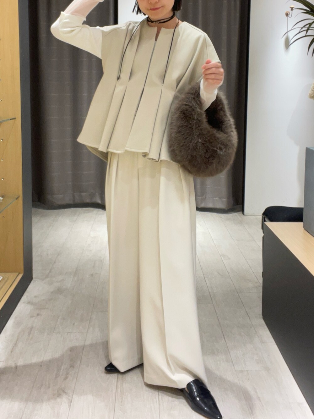 ベージュ系のベスト、ホワイト系のその他パンツ、ブラック系のパンプスを着用したレディースの秋コーディネートの4枚目の写真