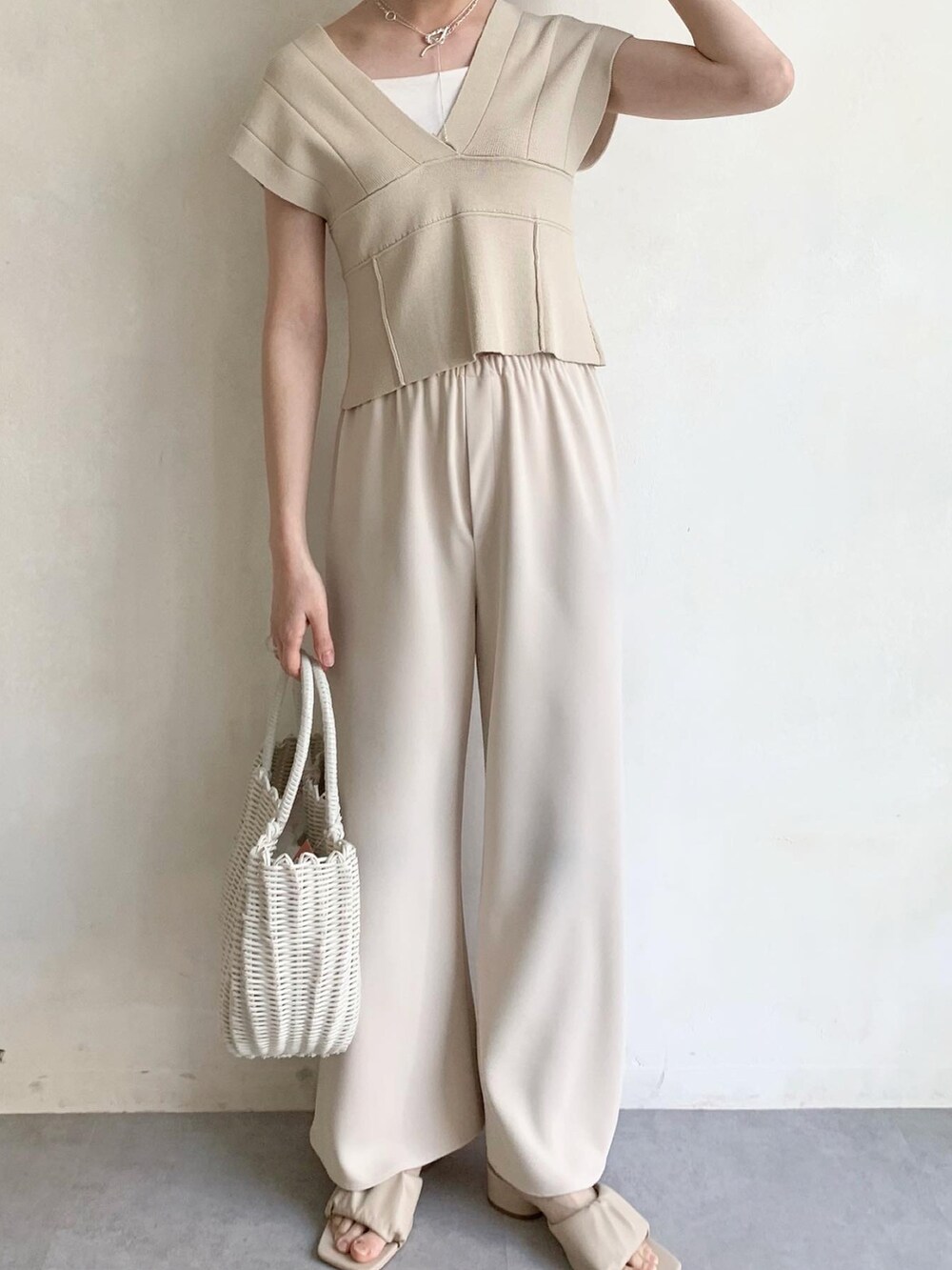 ホワイト系のハンドバッグ、ホワイト系のサンダル、ホワイト系のその他パンツを着用したレディースの夏コーディネートの2枚目の写真