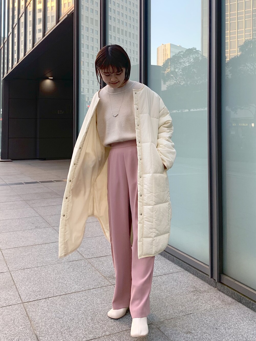ピンク系のその他パンツ、ベージュ系のニット/セーター、ホワイト系のノーカラーコートを着用したレディースの冬コーディネートの4枚目の写真