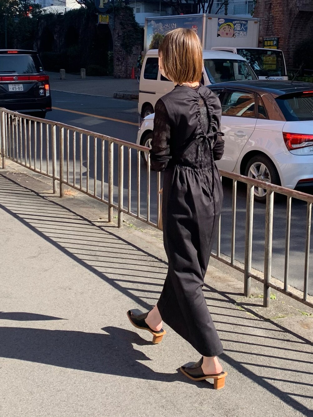 ブラック系のサンダル、ブラック系のワンピース、ブラック系のニット/セーターを着用したレディースの春コーディネートの4枚目の写真