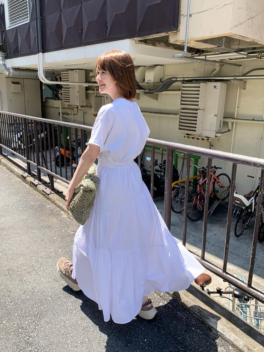 ホワイト系のTシャツ/カットソー、ホワイト系のスカート、シルバー系のその他シューズを着用したレディースの春コーディネートの4枚目の写真