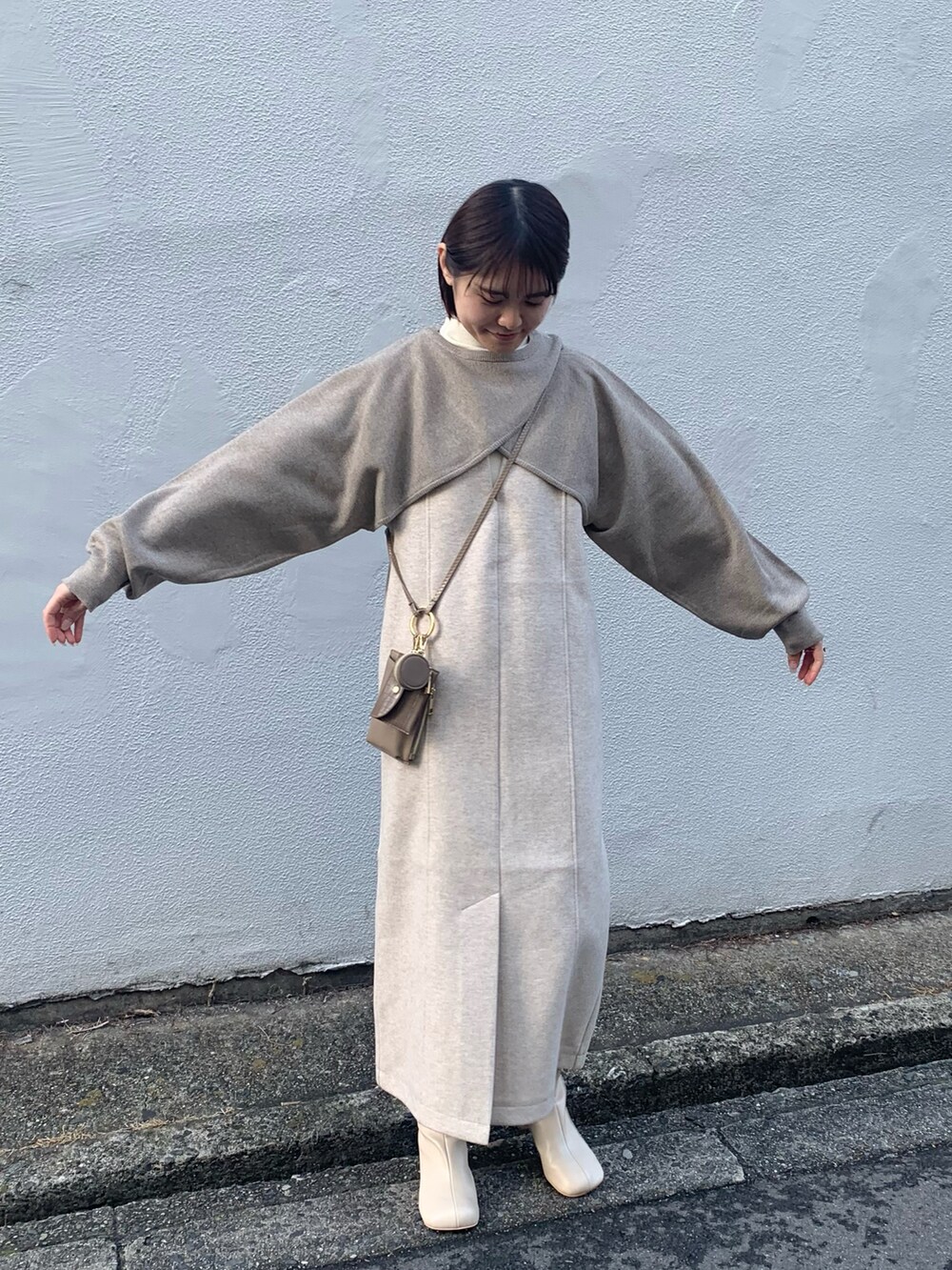 ホワイト系のブーツ、ブラック系のワンピース、ベージュ系のニット/セーターを着用したレディースの冬コーディネートの5枚目の写真