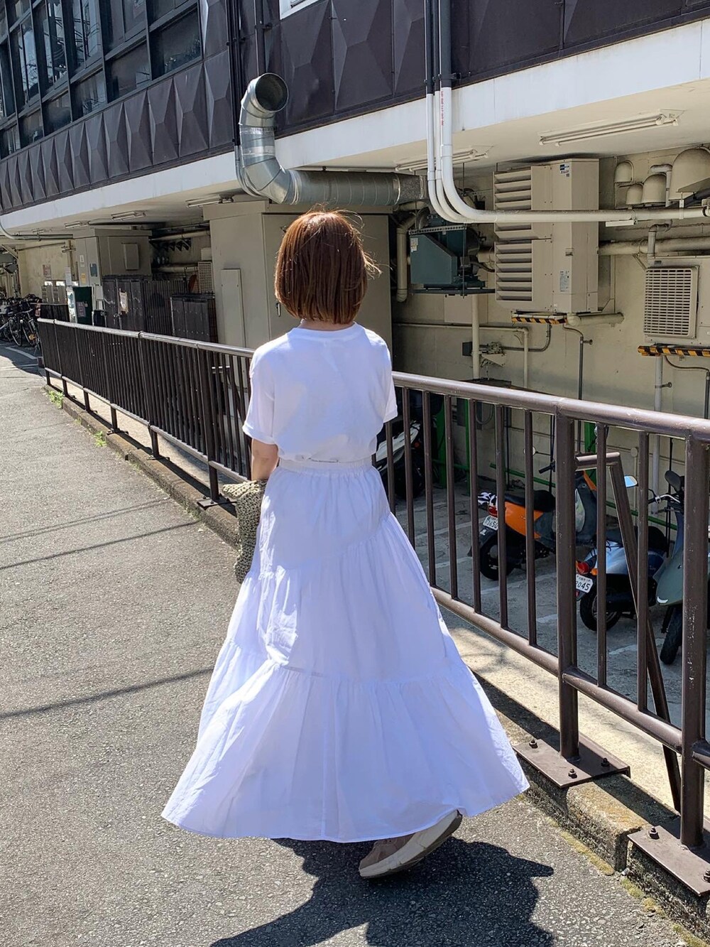 ホワイト系のTシャツ/カットソー、ホワイト系のスカート、シルバー系のその他シューズを着用したレディースの春コーディネートの5枚目の写真