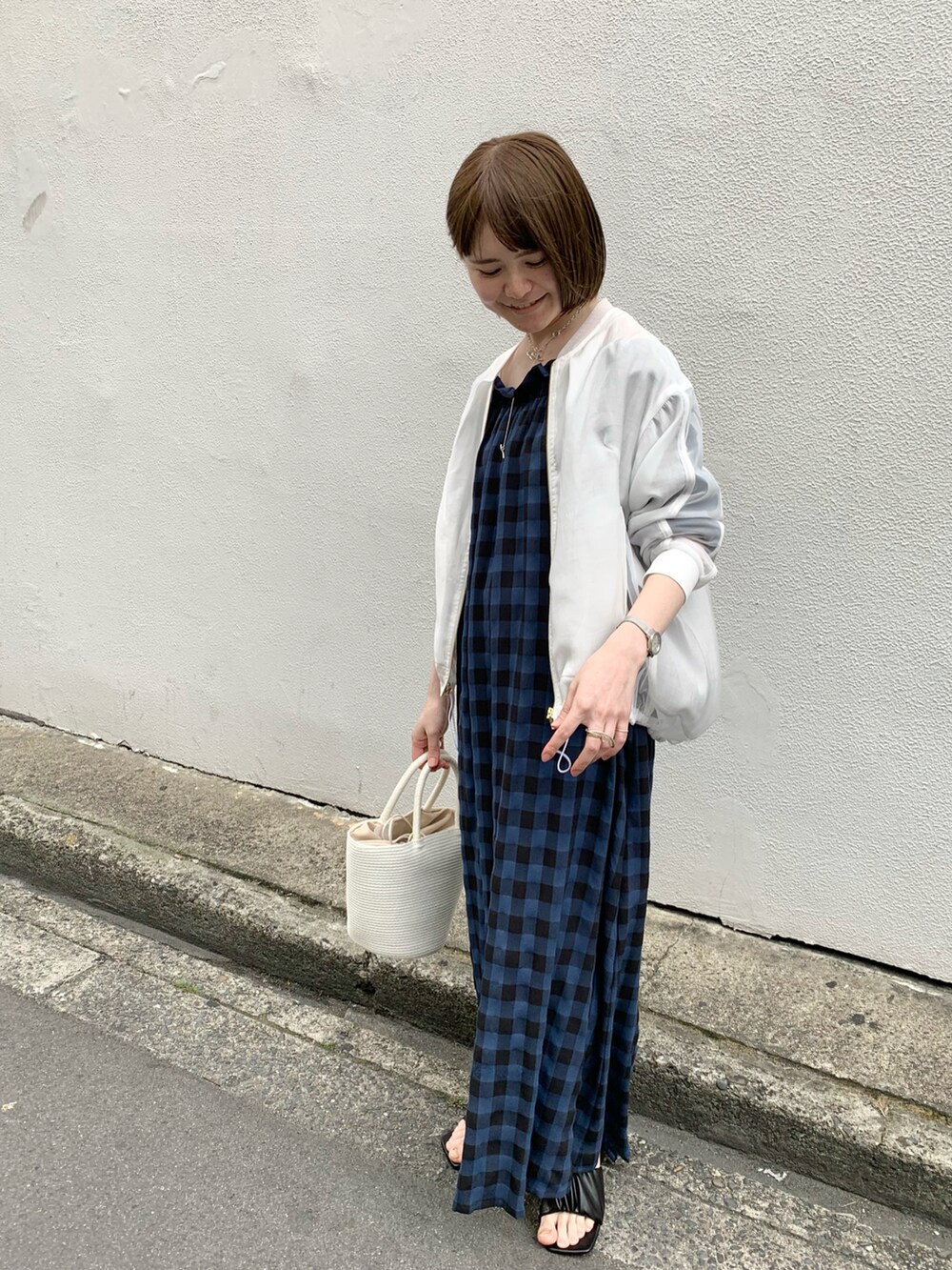 ホワイト系のトートバッグ、ブルー系のワンピース、ホワイト系のブルゾンを着用したレディースの春コーディネートの2枚目の写真