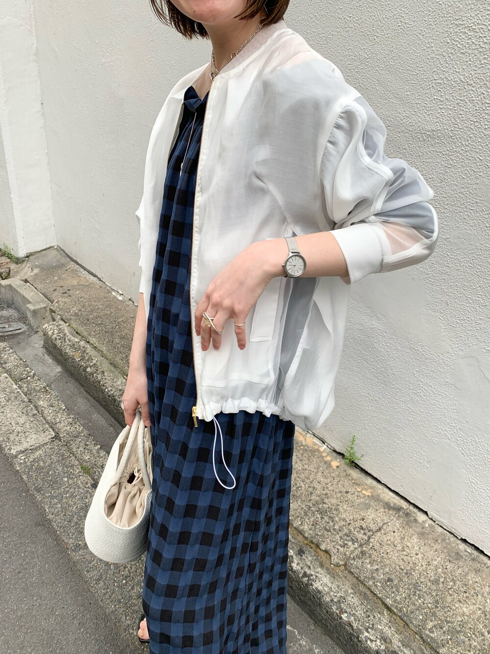 ホワイト系のトートバッグ、ブルー系のワンピース、ホワイト系のブルゾンを着用したレディースの春コーディネートの4枚目の写真