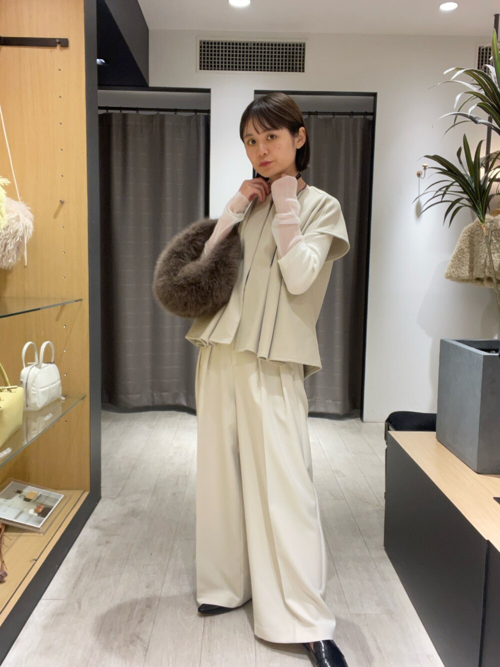 ベージュ系のベスト、ホワイト系のその他パンツ、ブラック系のパンプスを着用したレディースの秋コーディネートの3枚目の写真