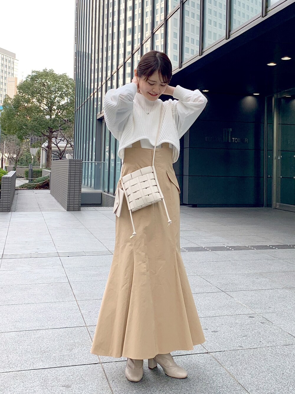 ホワイト系のブーツ、ベージュ系のスカート、ホワイト系のショルダーバッグを着用したレディースの冬コーディネートの4枚目の写真