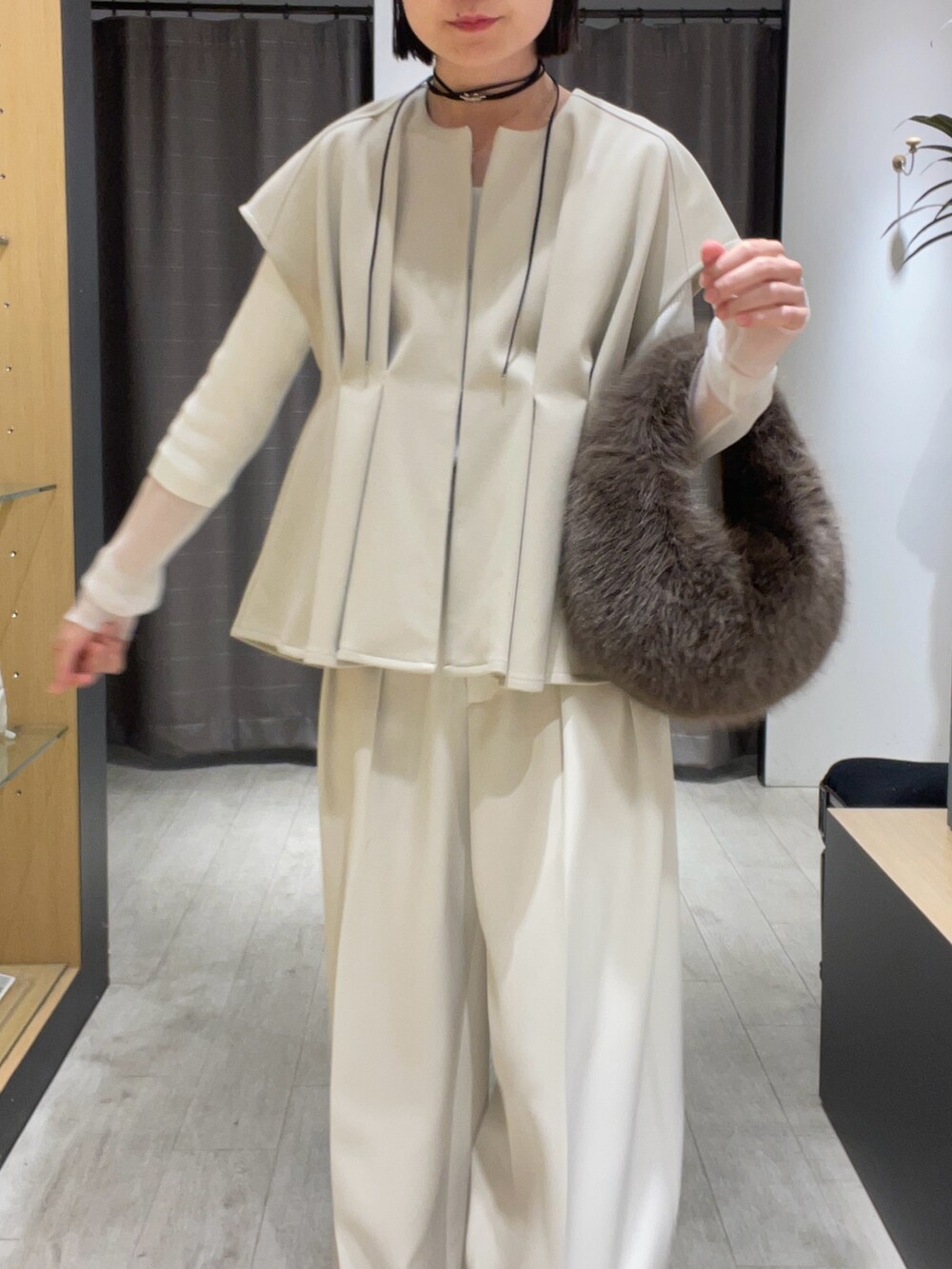 ベージュ系のベスト、ホワイト系のその他パンツ、ブラック系のパンプスを着用したレディースの秋コーディネートの5枚目の写真