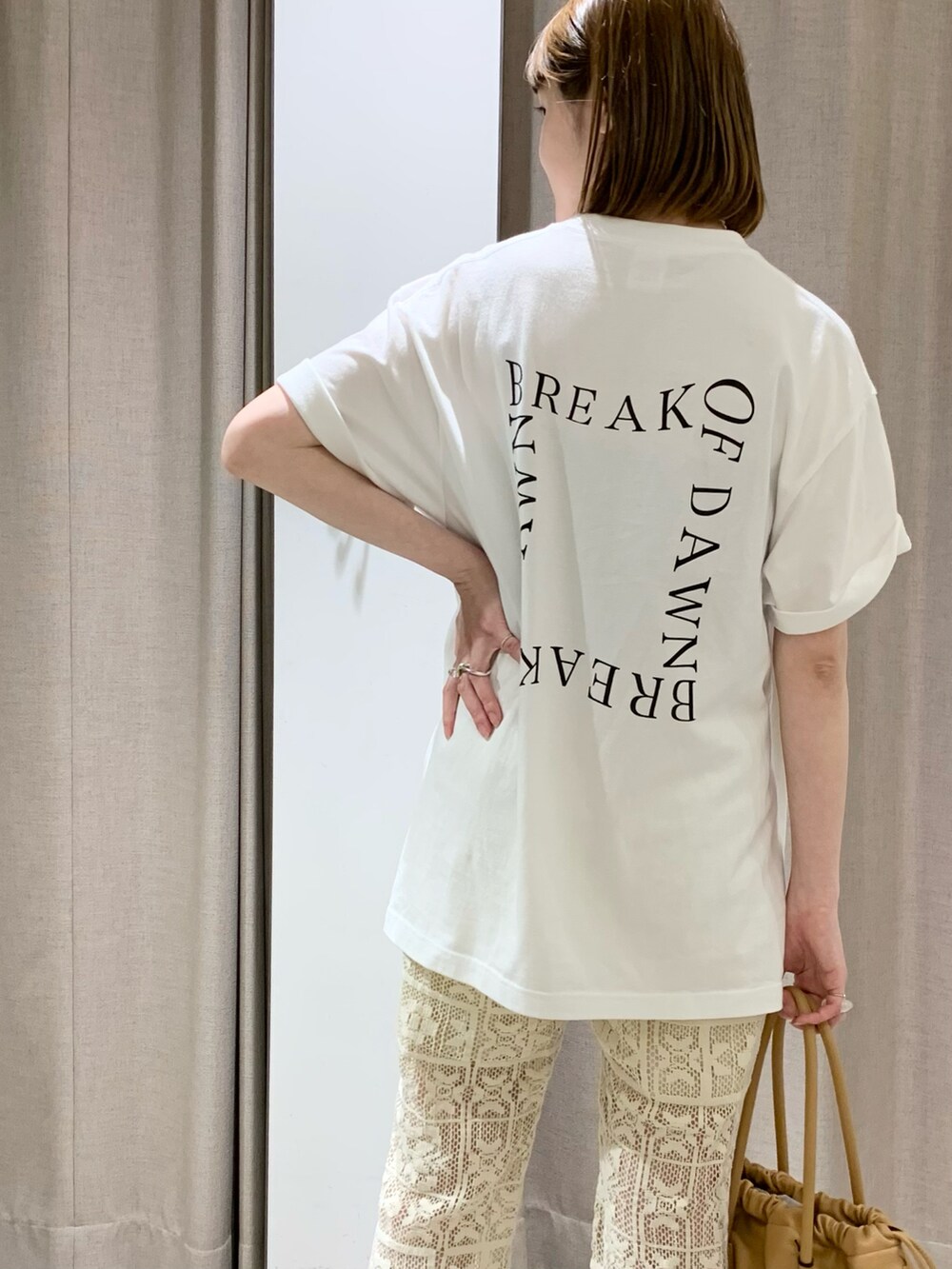 ホワイト系のその他パンツ、イエロー系のトートバッグ、ベージュ系のスニーカーを着用したレディースの夏コーディネートの2枚目の写真