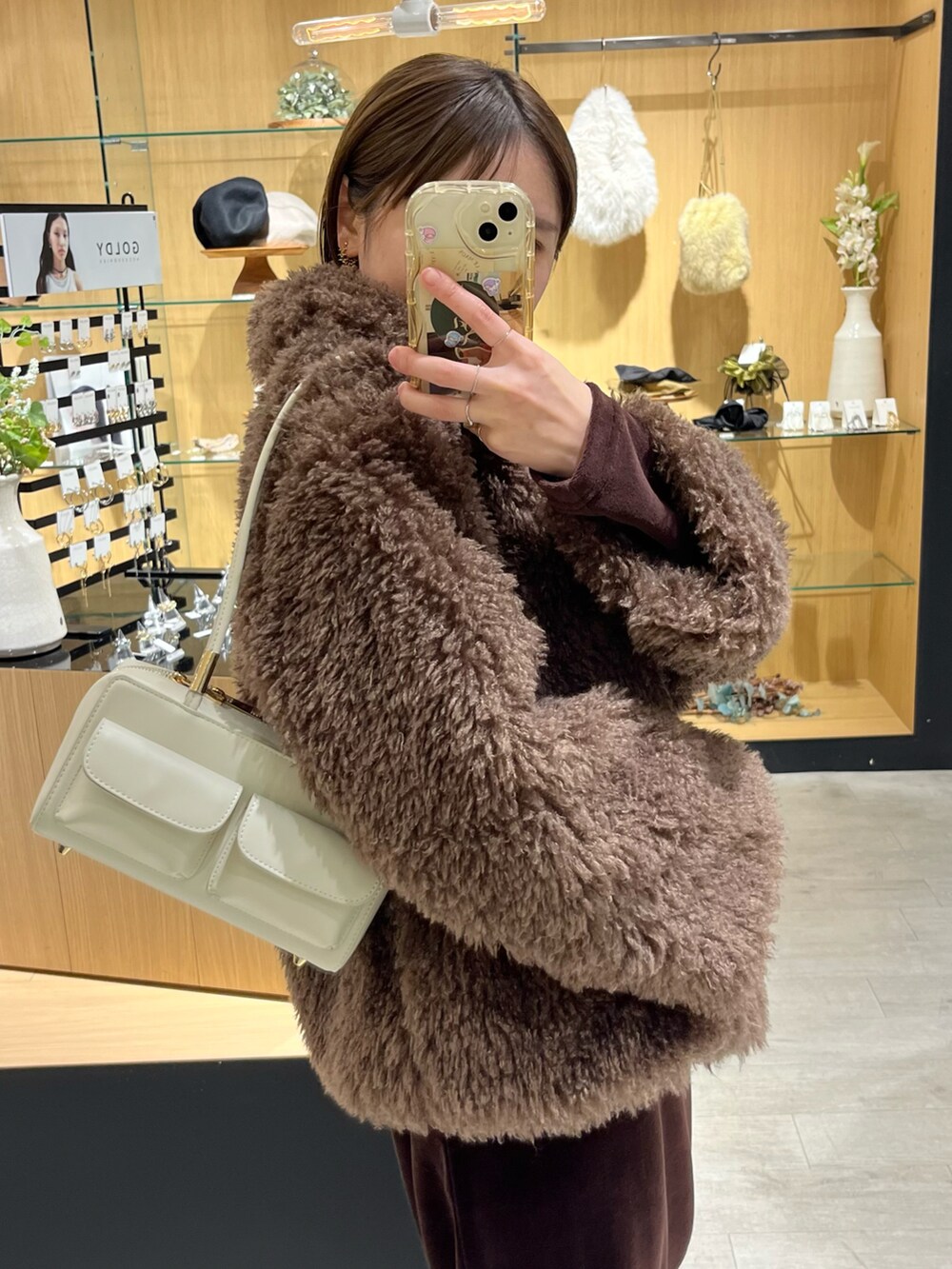 ホワイト系のバッグ、ブラウン系のその他アウター、ブラウン系のブーツを着用したレディースの冬コーディネートの4枚目の写真