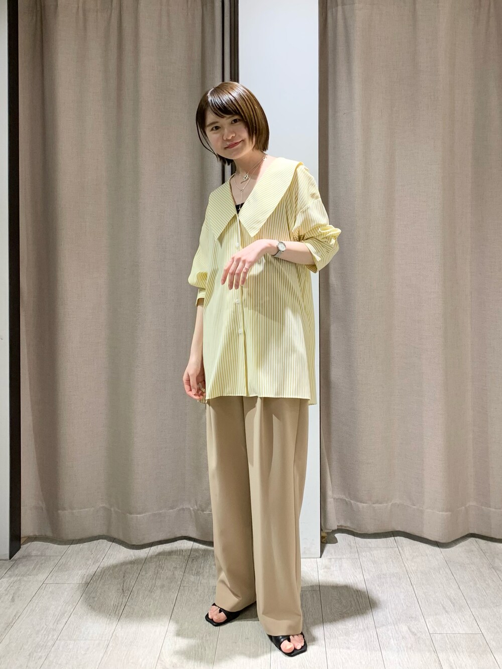 ブルー系のデニムパンツ、ブラック系のサンダル、ホワイト系のサンダルを着用したレディースの春コーディネートの5枚目の写真