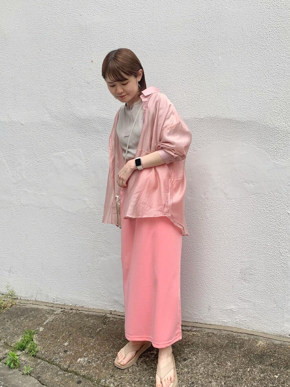 ピンク系のシャツ/ブラウス、ピンク系のスカート、ホワイト系のショルダーバッグを着用したレディースの春コーディネートの2枚目の写真