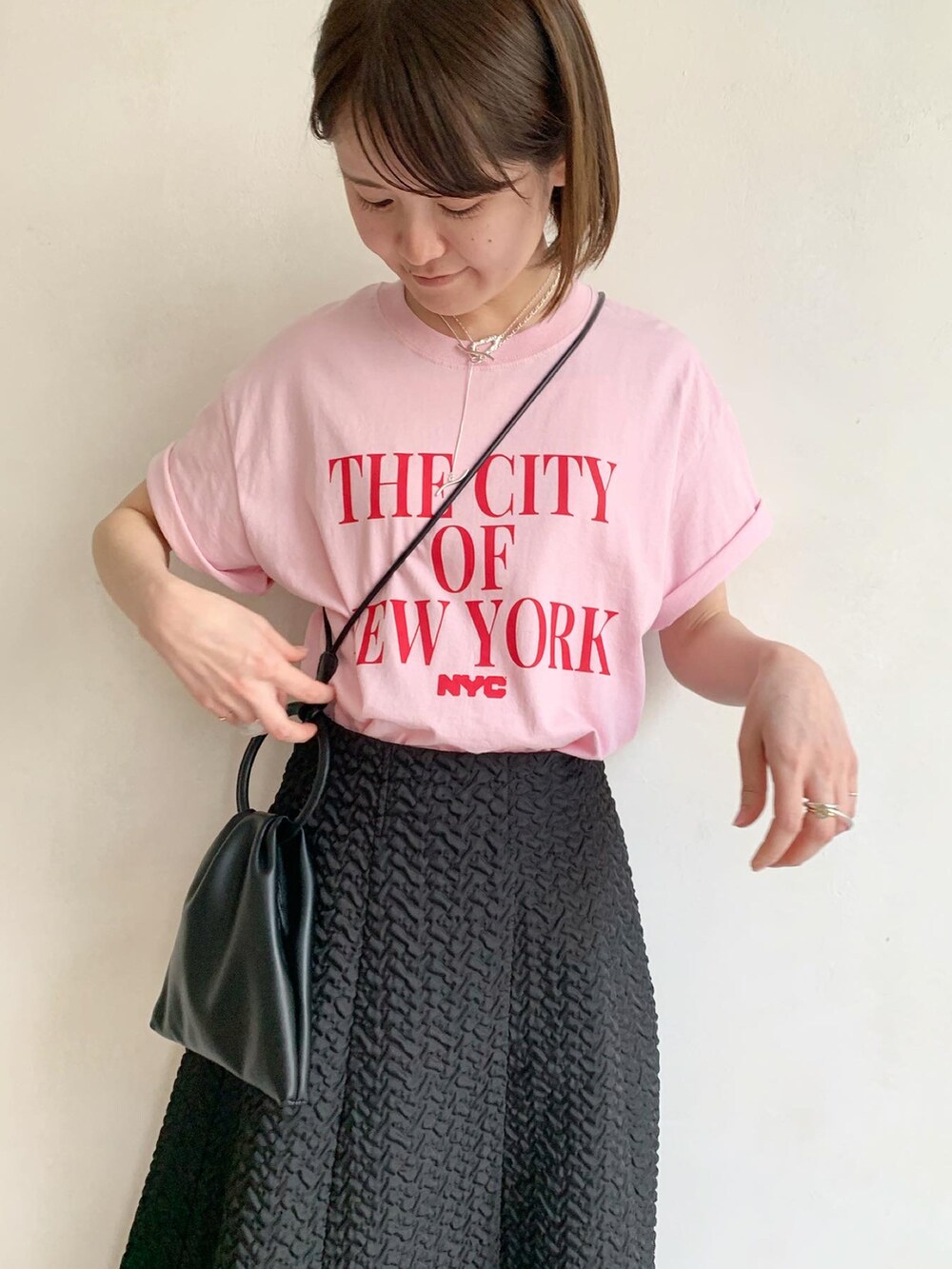 ピンク系のTシャツ/カットソー、ブラック系のサンダル、ブラック系のスカートを着用したレディースの春コーディネートの5枚目の写真