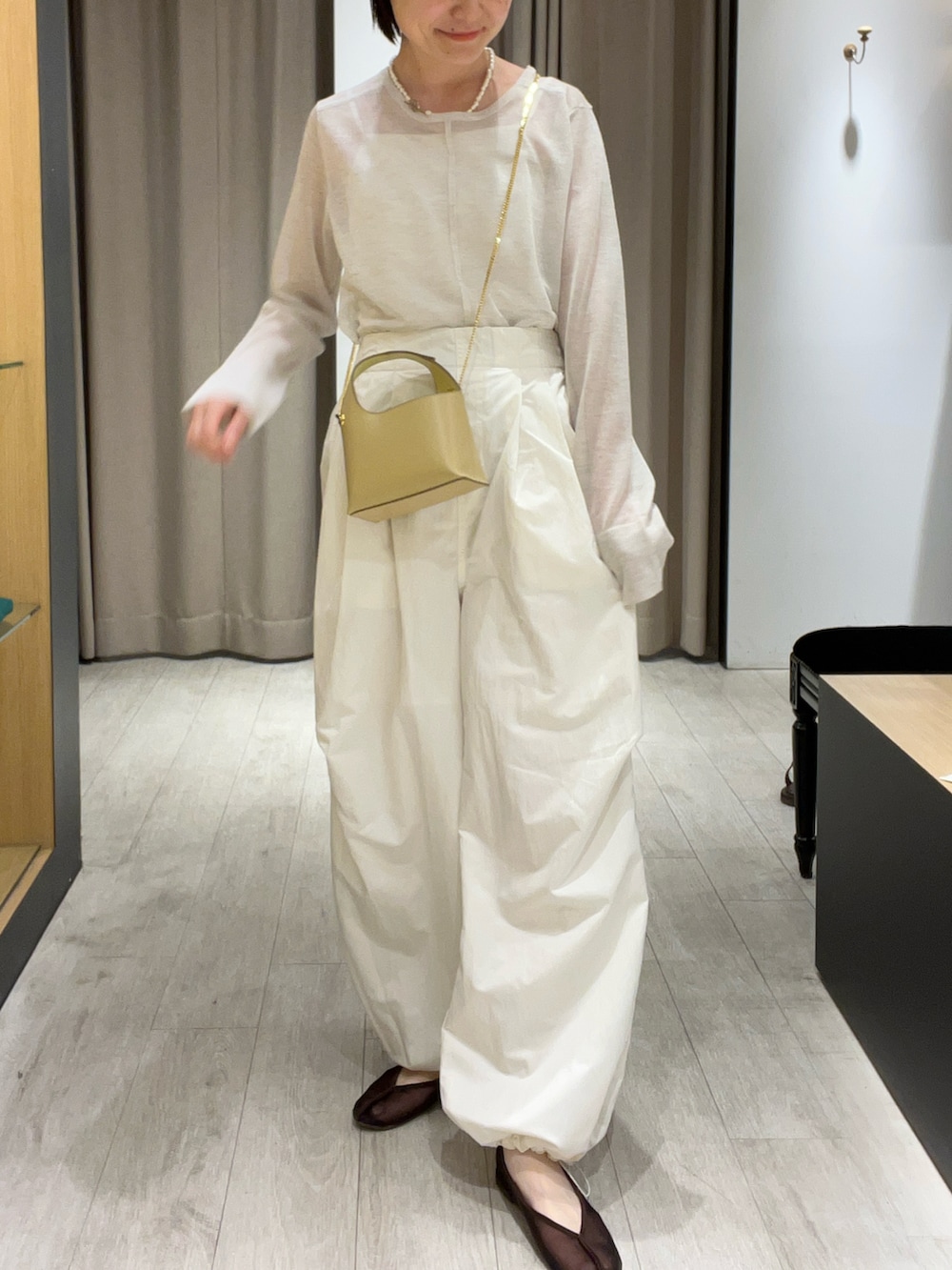 ブラウン系のバレエシューズ、ホワイト系のその他パンツ、ベージュ系のショルダーバッグを着用したレディースの夏コーディネートの2枚目の写真