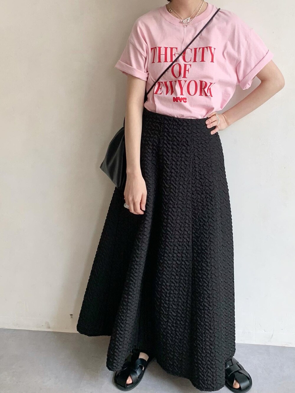 ピンク系のTシャツ/カットソー、ブラック系のサンダル、ブラック系のスカートを着用したレディースの春コーディネートの2枚目の写真