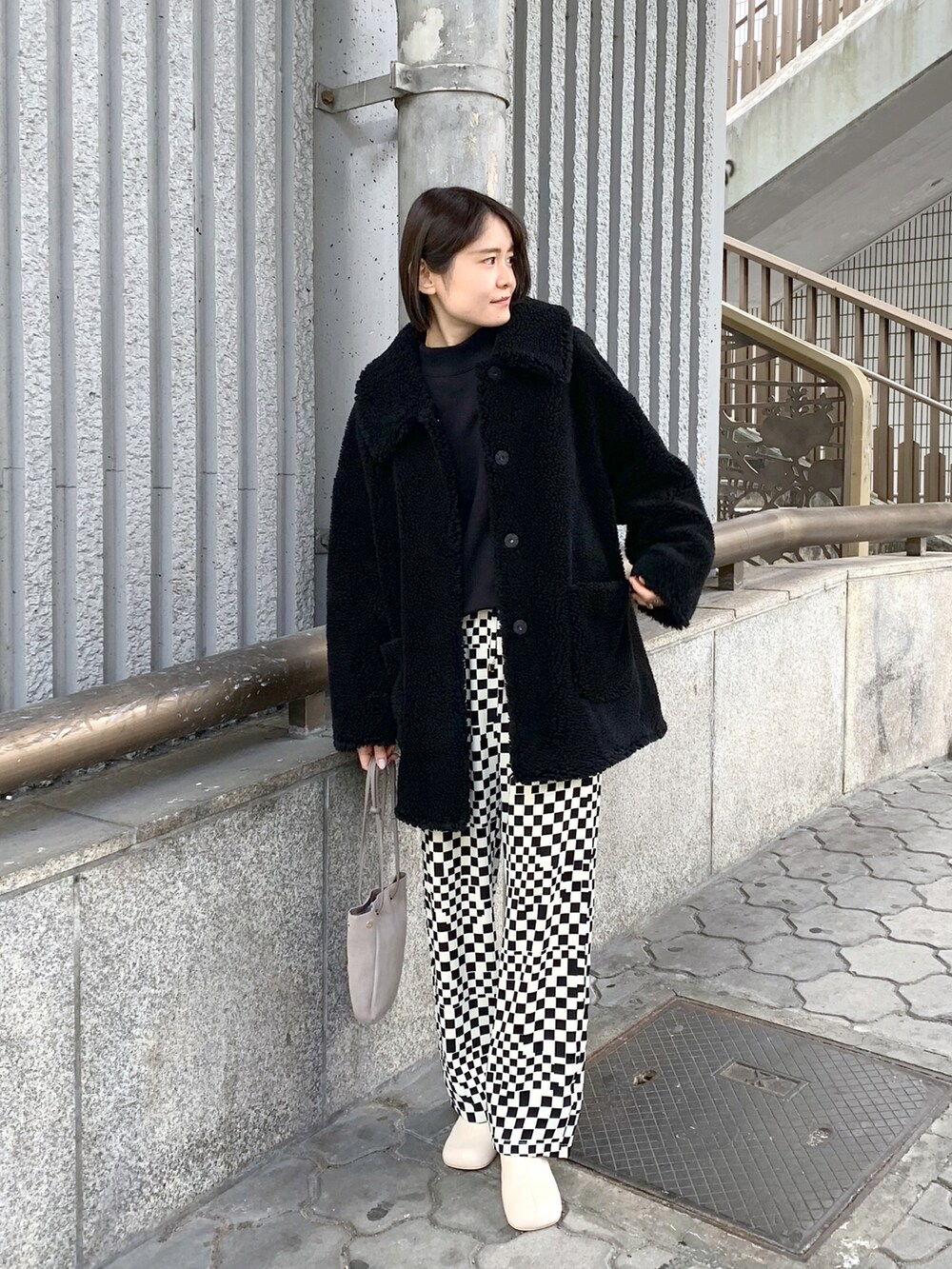 ブラック系のブルゾン、ホワイト系のその他パンツ、グレー系のショルダーバッグを着用したレディースの冬コーディネートの2枚目の写真