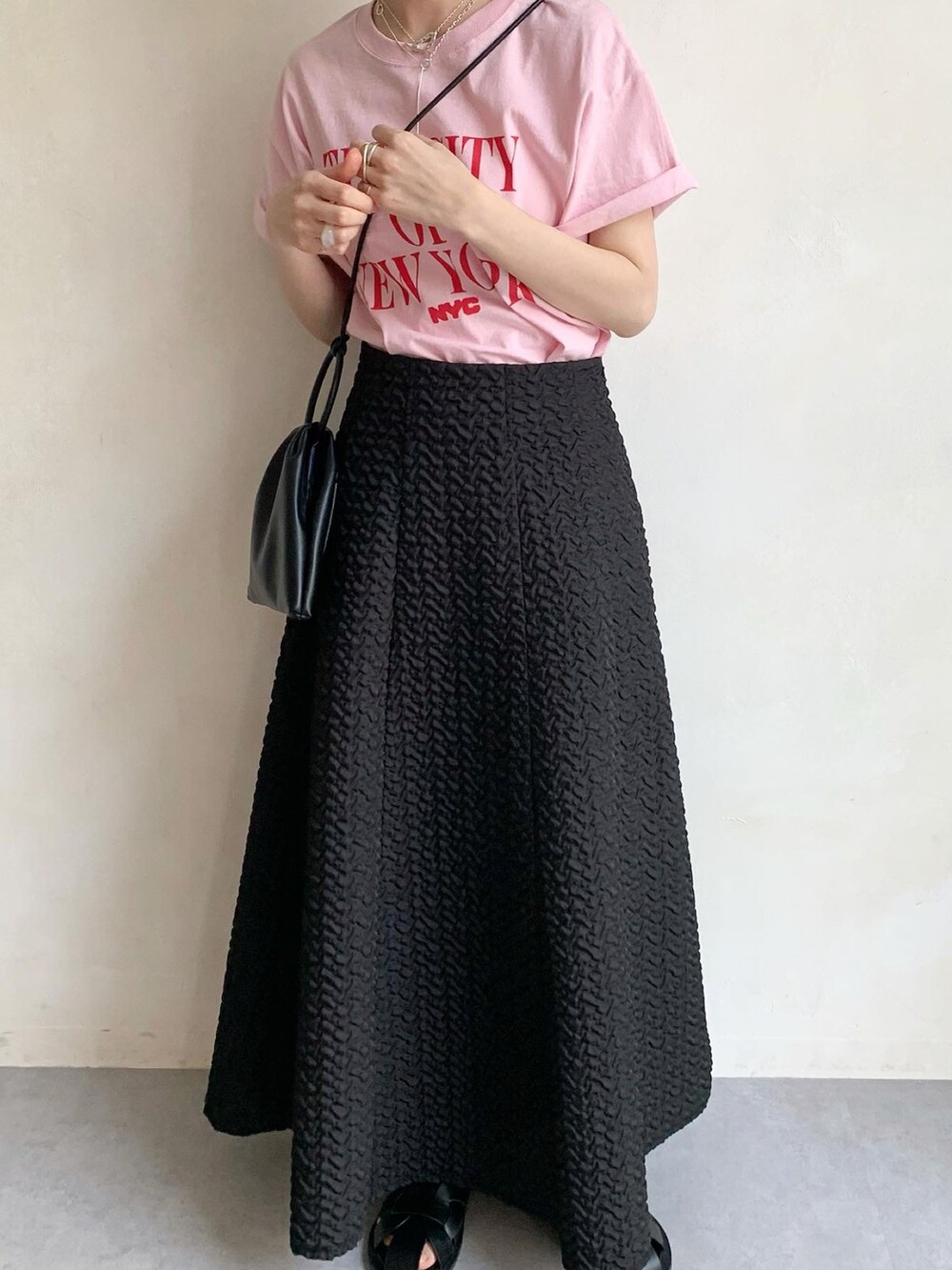 ピンク系のTシャツ/カットソー、ブラック系のサンダル、ブラック系のスカートを着用したレディースの春コーディネートの3枚目の写真