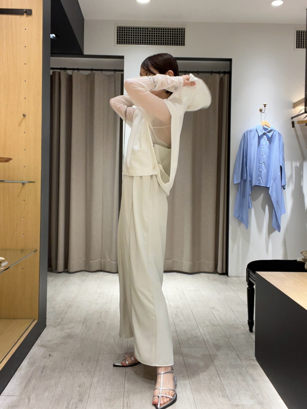 シルバー系のサンダル、ベージュ系のショルダーバッグ、ホワイト系のワンピースを着用したレディースの夏コーディネートの4枚目の写真