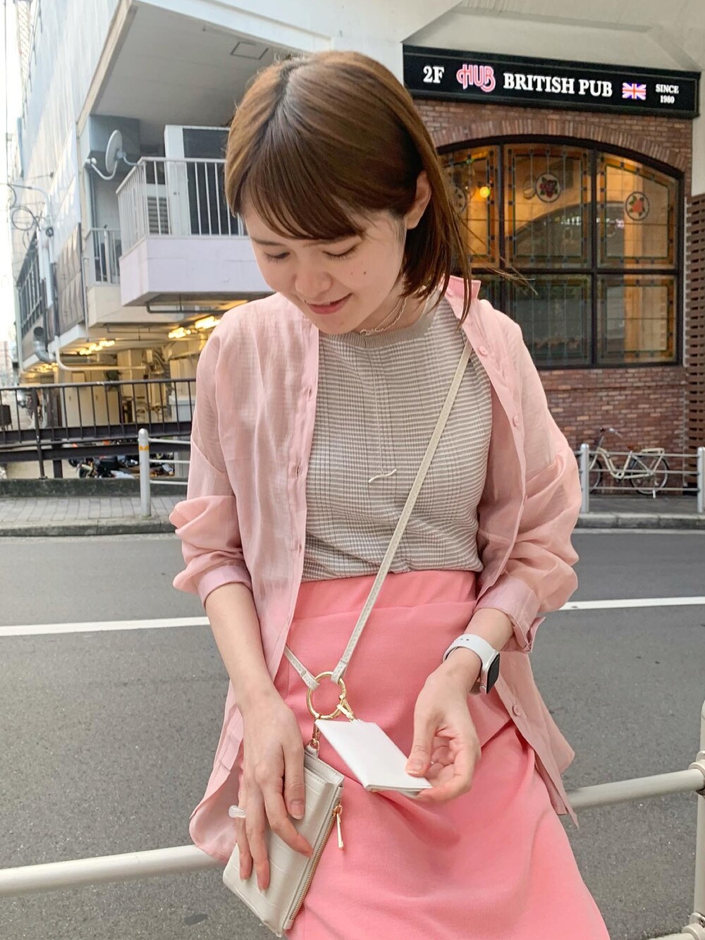 ピンク系のシャツ/ブラウス、ピンク系のスカート、ホワイト系のショルダーバッグを着用したレディースの春コーディネートの3枚目の写真