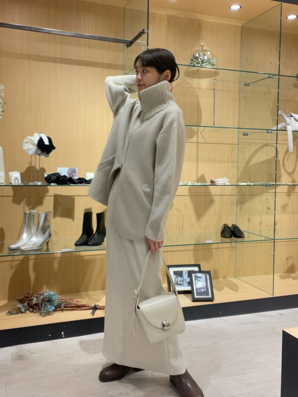 ホワイト系のショルダーバッグ、ホワイト系のその他アウター、ブラウン系のパンプスを着用したレディースの秋コーディネートの2枚目の写真