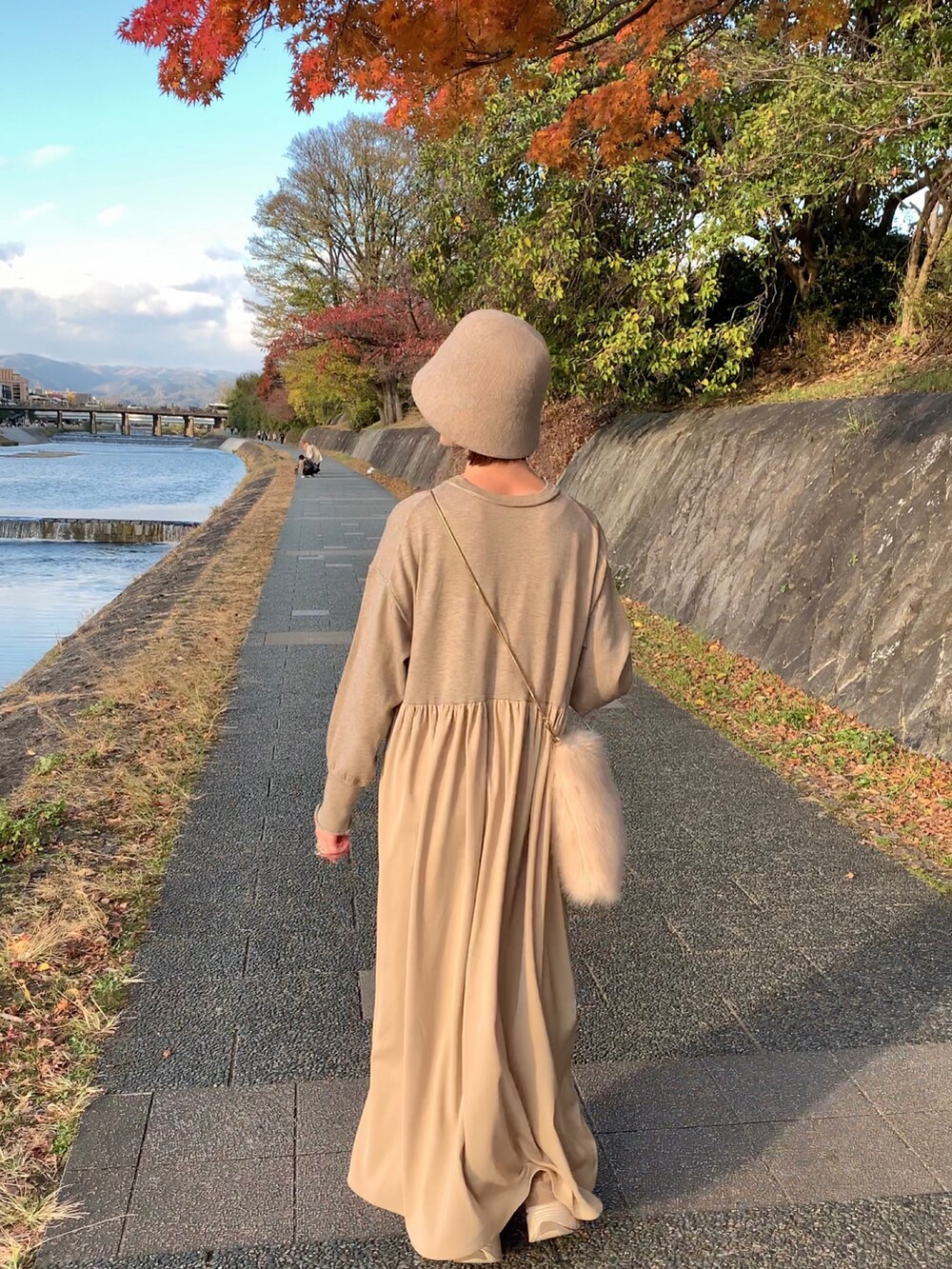 ベージュ系のスニーカー、ベージュ系のワンピース、ベージュ系のショルダーバッグを着用したレディースの秋コーディネートの5枚目の写真