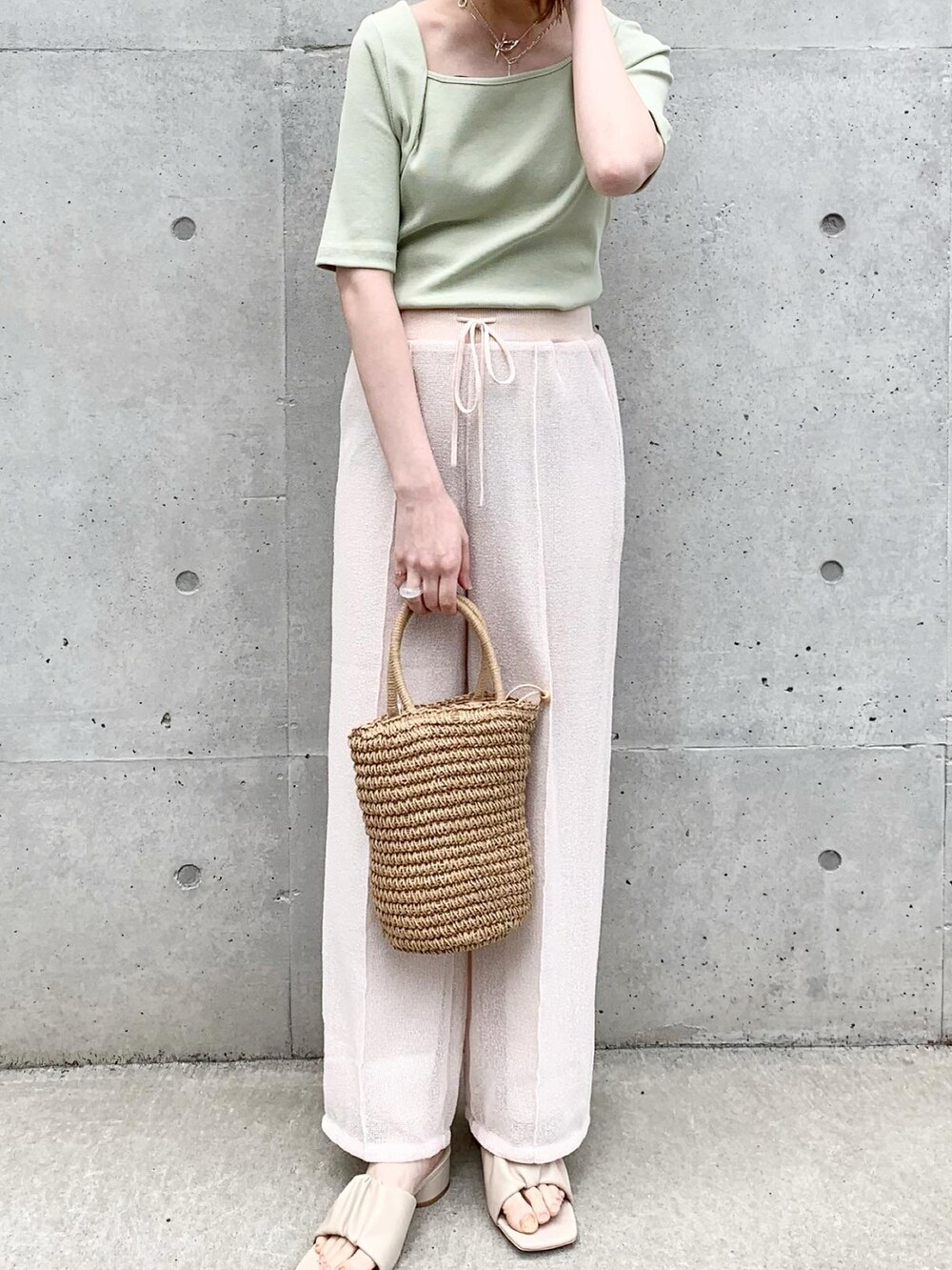 ホワイト系のサンダル、ベージュ系のハンドバッグ、グリーン系のTシャツ/カットソーを着用したレディースの春コーディネートの3枚目の写真