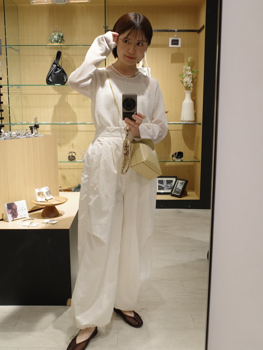 ブラウン系のバレエシューズ、ホワイト系のその他パンツ、ベージュ系のショルダーバッグを着用したレディースの夏コーディネートの4枚目の写真