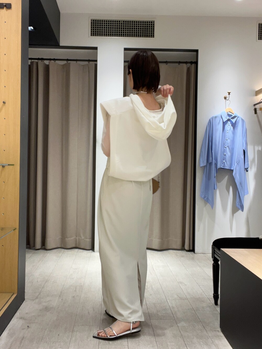 シルバー系のサンダル、ベージュ系のショルダーバッグ、ホワイト系のワンピースを着用したレディースの夏コーディネートの5枚目の写真