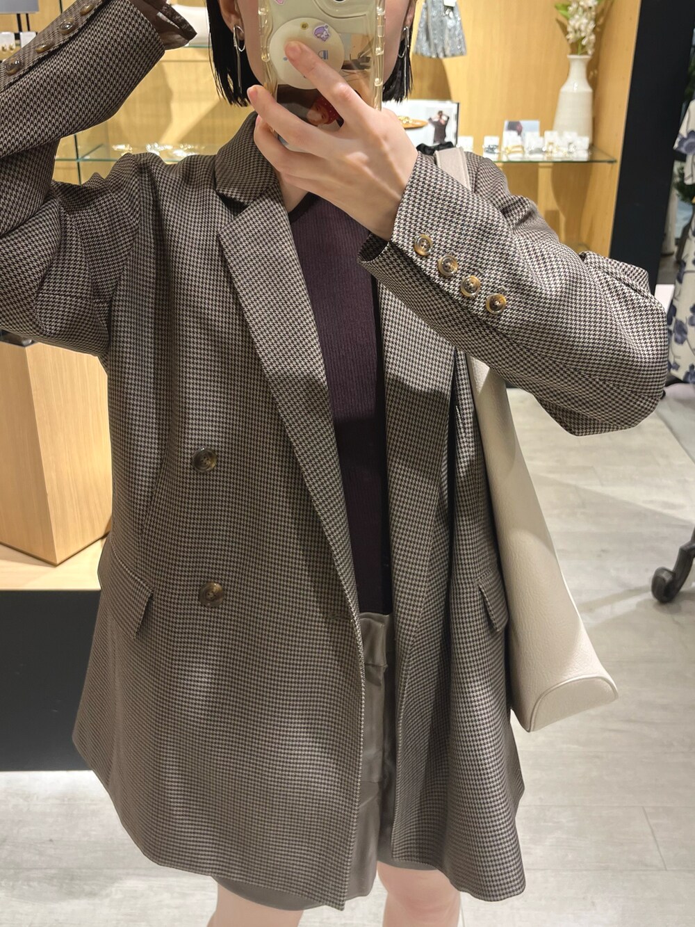 ブラウン系のテーラードジャケット、ブラウン系のニット/セーター、ホワイト系のトートバッグを着用したレディースの夏コーディネートの3枚目の写真