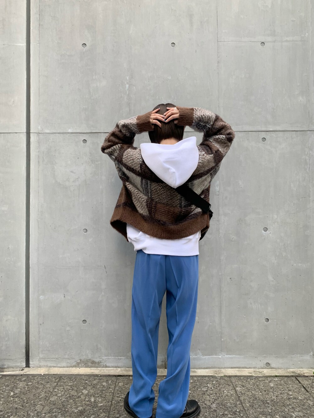 ブルー系のその他パンツ、ブラック系のクラッチバッグ、ブラウン系のカーディガン/ボレロを着用したレディースの冬コーディネートの3枚目の写真