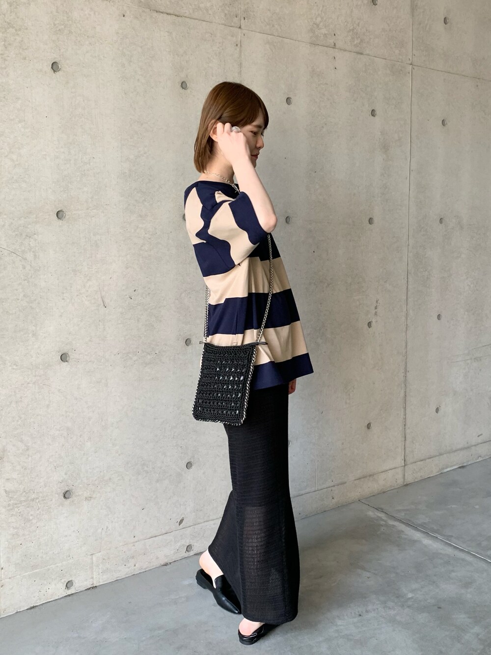 ブラック系のその他シューズ、ブラック系のスカート、ベージュ系のTシャツ/カットソーを着用したレディースの春コーディネートの2枚目の写真