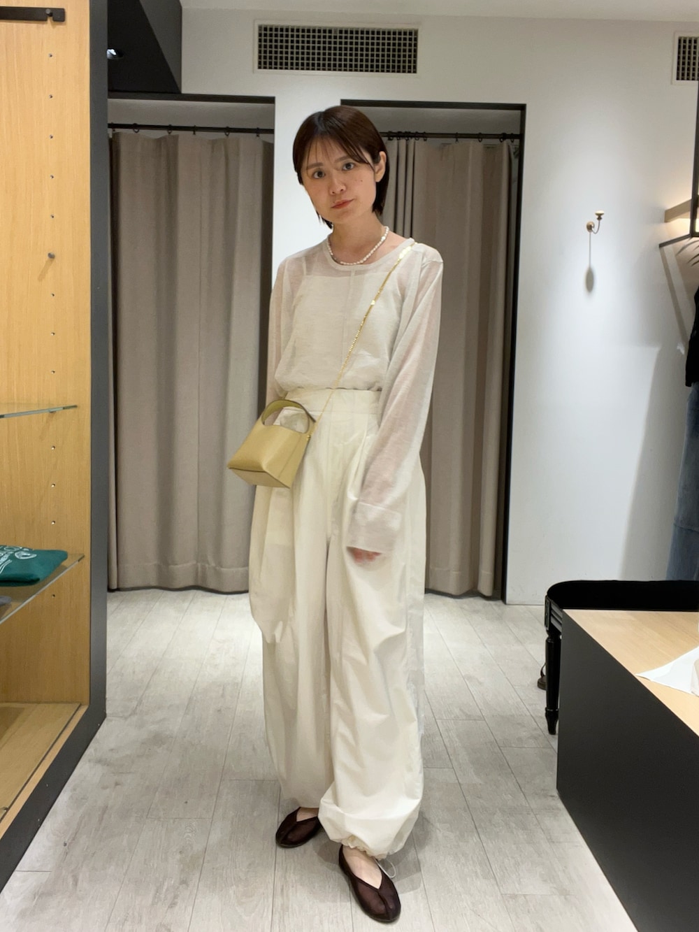 ブラウン系のバレエシューズ、ホワイト系のその他パンツ、ベージュ系のショルダーバッグを着用したレディースの夏コーディネートの3枚目の写真