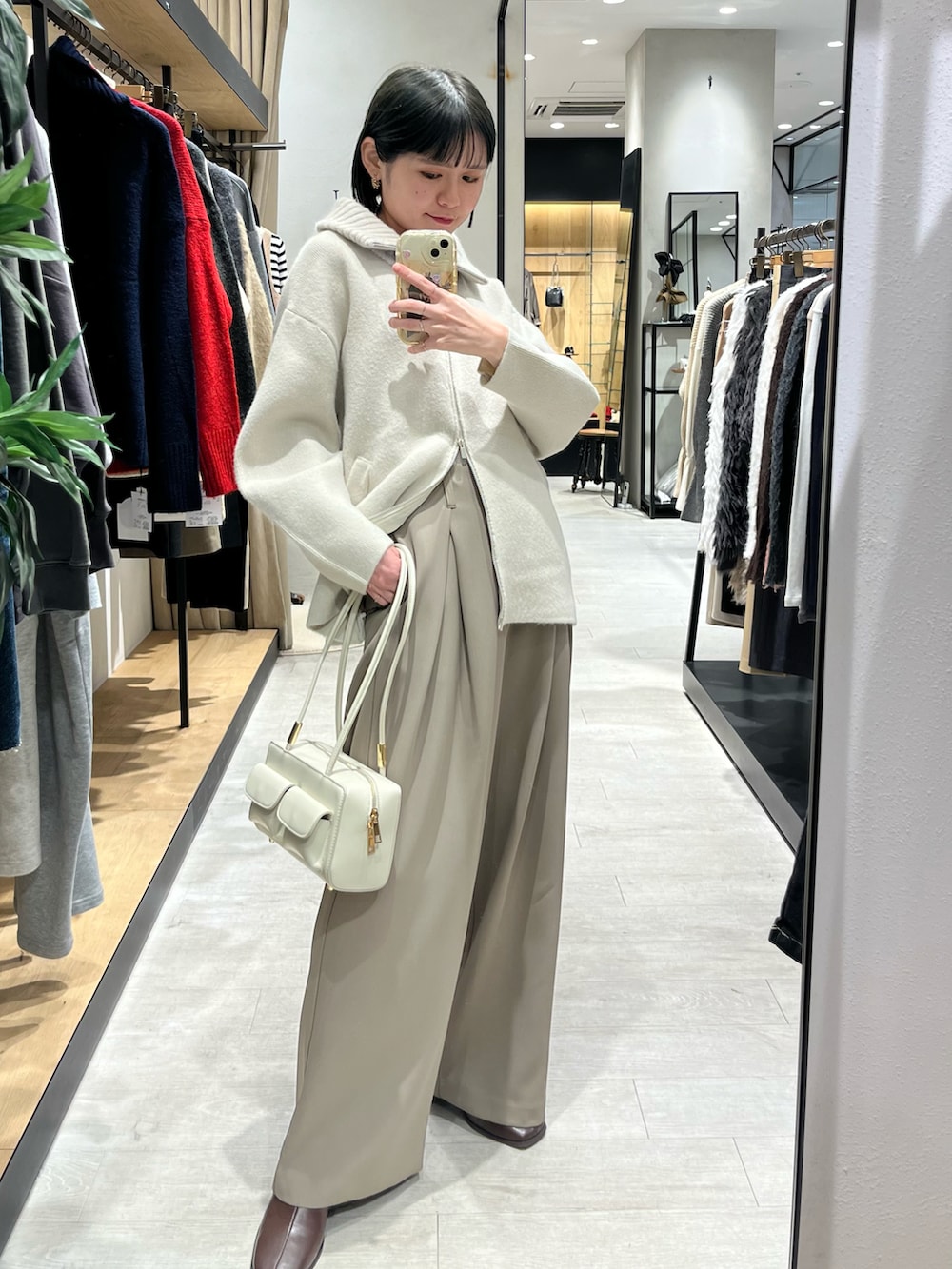 ホワイト系のその他アウター、ベージュ系のその他パンツ、ブラウン系のブーツを着用したレディースの冬コーディネートの2枚目の写真