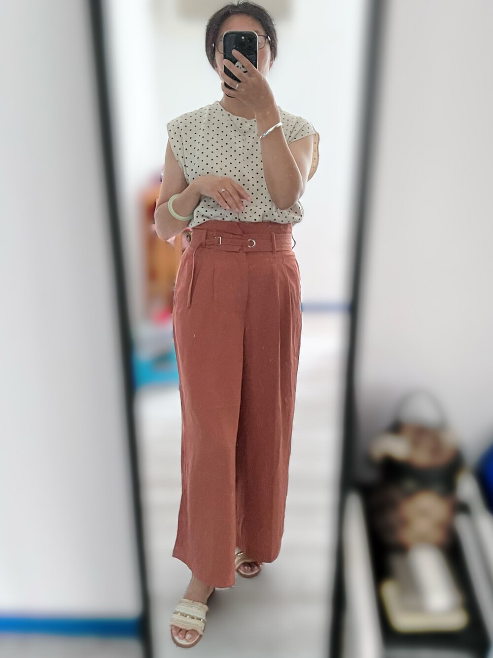 オレンジ系のチノパンツを着用したレディースの秋コーディネートの2枚目の写真