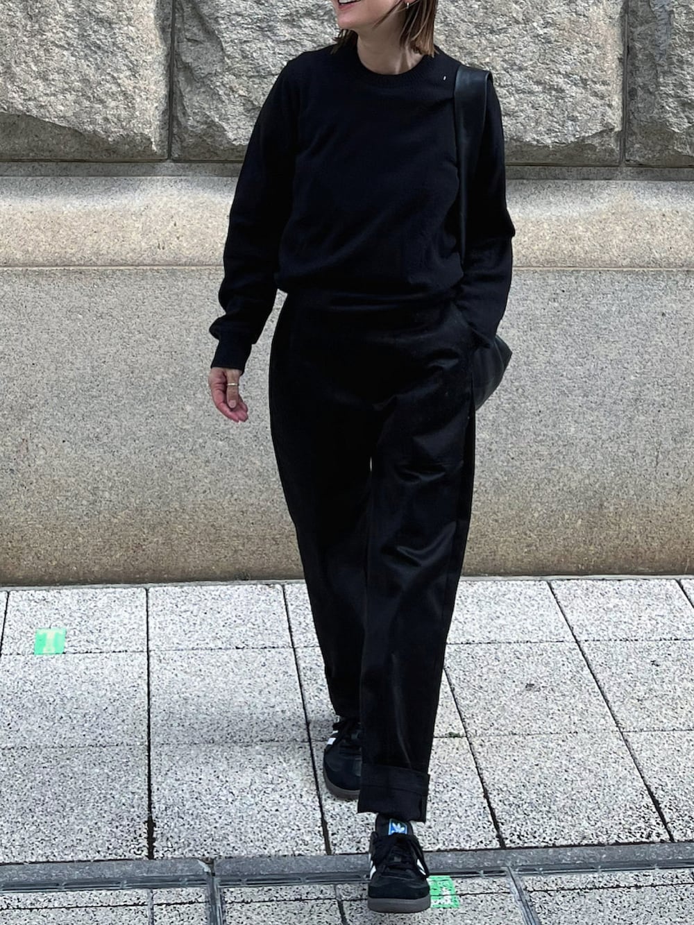 ブラック系のニット/セーター、ブラック系のショルダーバッグ、ブラック系のパンツを着用したレディースの秋コーディネートの3枚目の写真