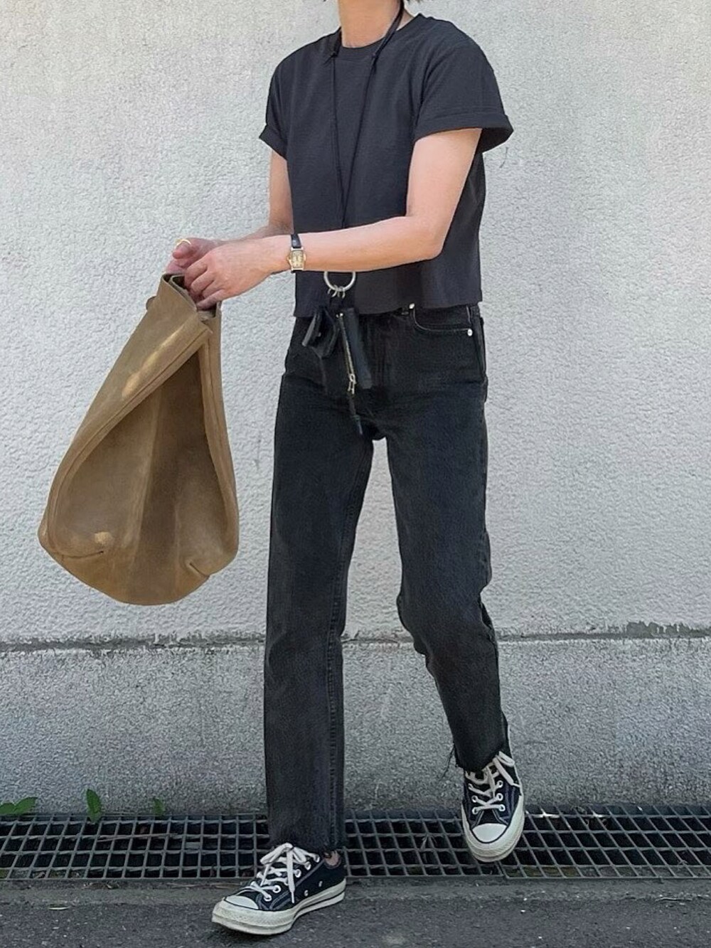 ブラック系のデニムパンツ、ベージュ系のバッグを着用したレディースの夏コーディネートの2枚目の写真
