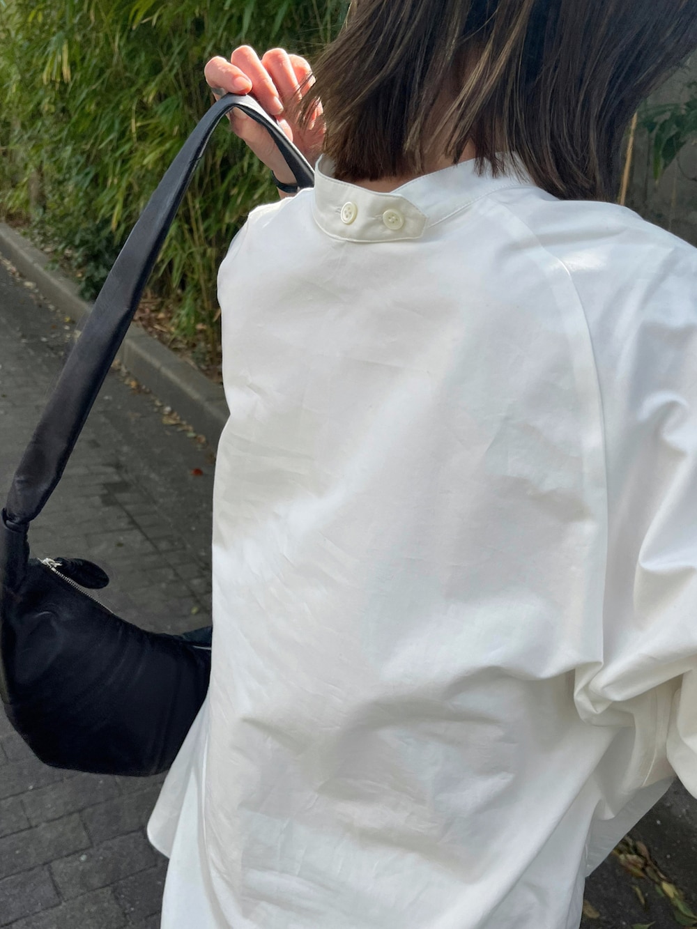 ホワイト系のシャツ/ブラウス、ホワイト系のパンツ、ブラック系のブーツを着用したレディースの春コーディネートの5枚目の写真