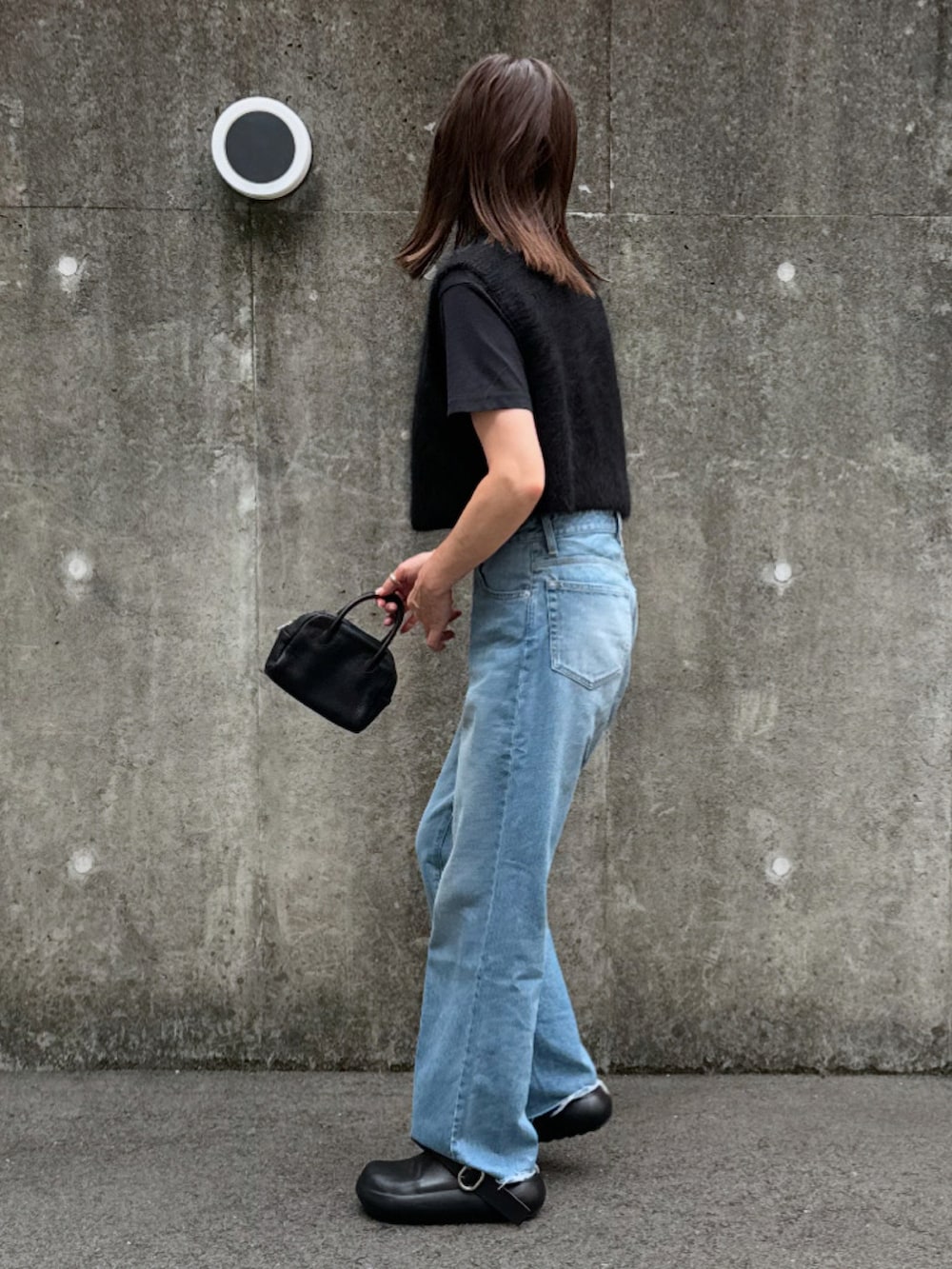 グレー系のニット/セーター、ブルー系のデニムパンツ、ブラック系のその他シューズを着用したレディースの夏コーディネートの2枚目の写真